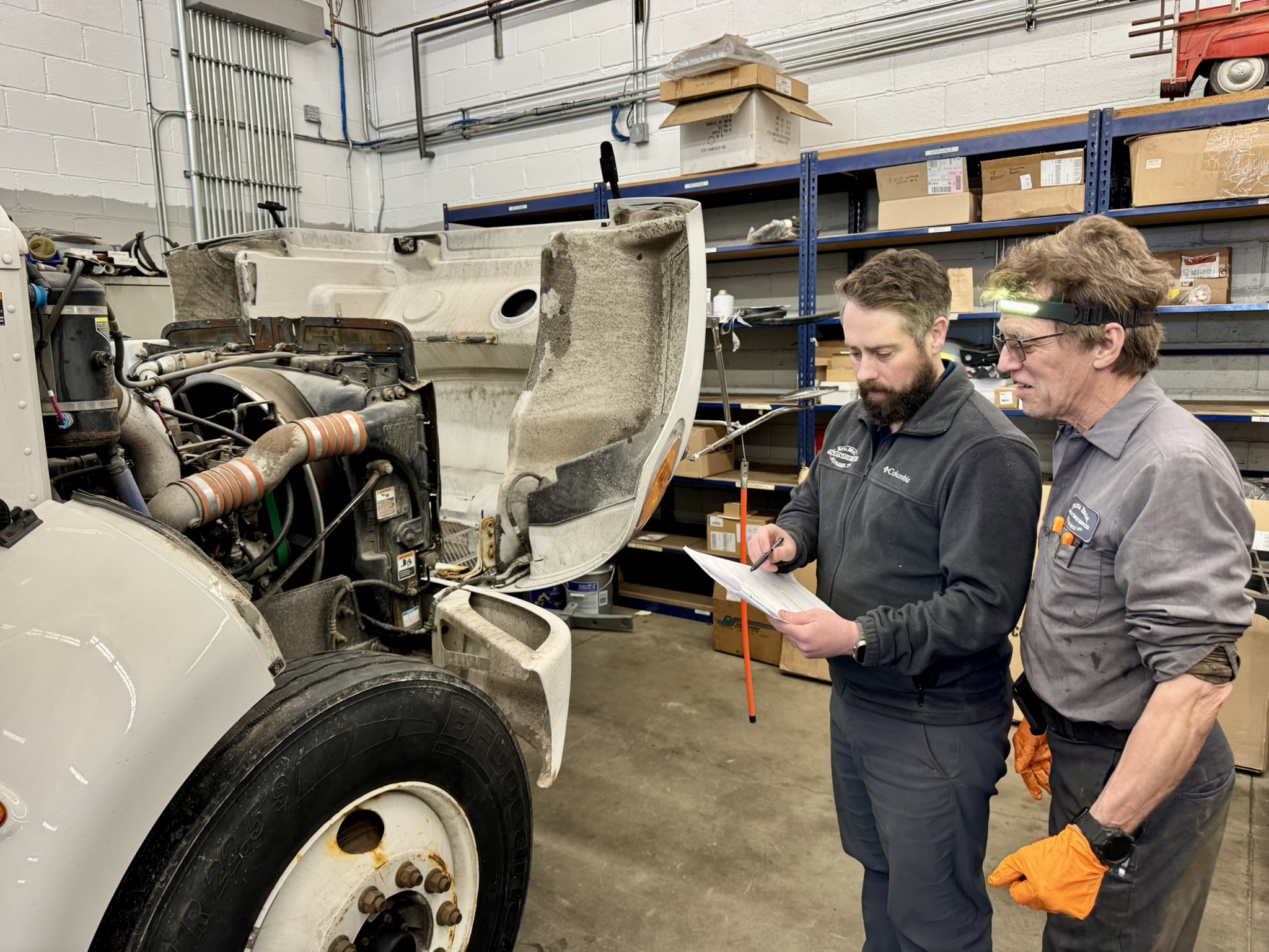Two mechanics discussing the diagnosis of a truck