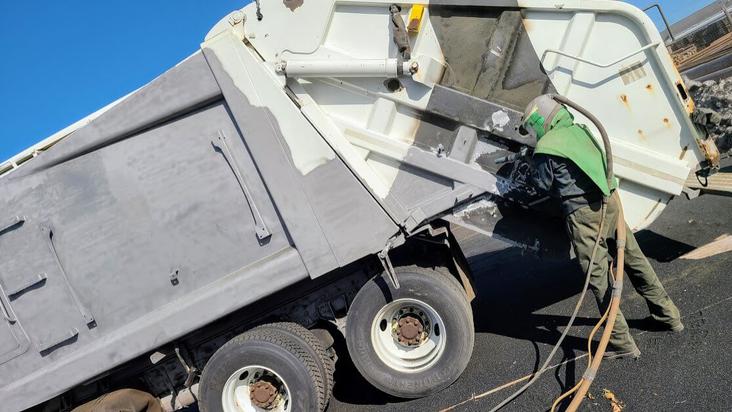 Garbage truck being sandblasted